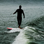 Silhouette of surfer longboarding